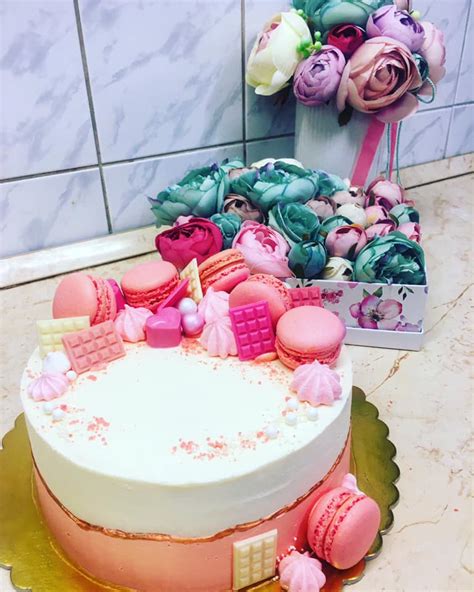 Színes macaronok és vajkrémmel díszített torta