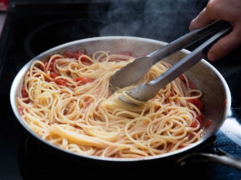 Mixing pasta and sauce in a pan