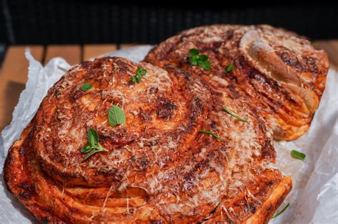 frissen sült, gőzölgő pizzás csigák egy fatálcán