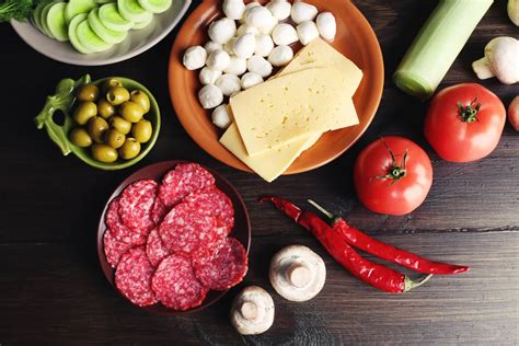 Diétás pizza egy asztalon, friss zöldségekkel és fűszerekkel