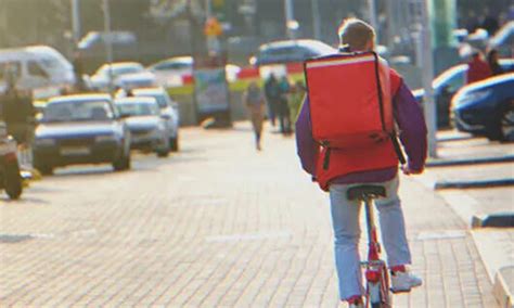 Egy futár biciklin ételt szállít