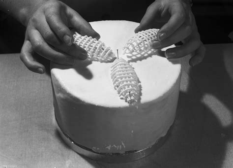 Fiatal cukrásztanuló tortát díszít