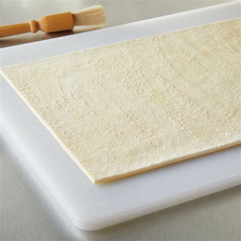 Puff pastry sheets on a cutting board with flour