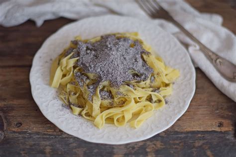 Mákos tészta egy tányéron, tetején friss mákkal szórva