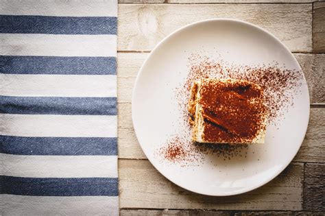 Tiramisu egy szelet citrommal és citromfűvel díszítve