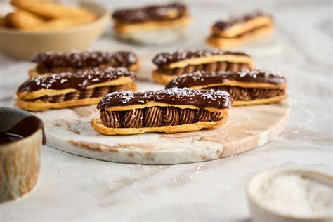 Különböző ízesítésű éclair fánkok sorakoznak egy cukrászdában