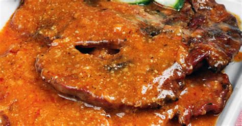 egy tányér ínycsiklandó, szaftos rozsdás hús, frissen tálalva, gazdag barna mártással leöntve