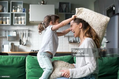 egy anya és gyermeke együtt játszik mosolyogva a nappaliban
