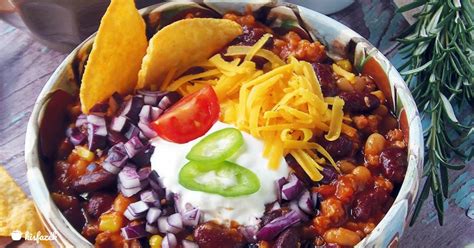 tál chilis bab friss kenyérrel, tejföllel és lime szelettel