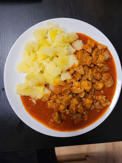 Tálalt csülökpörkölt főtt krumplival és savanyúsággal