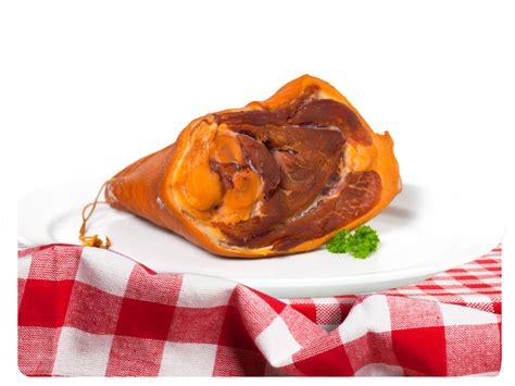 Füstölt csülök egy vágódeszkán, fűszerekkel körülvéve