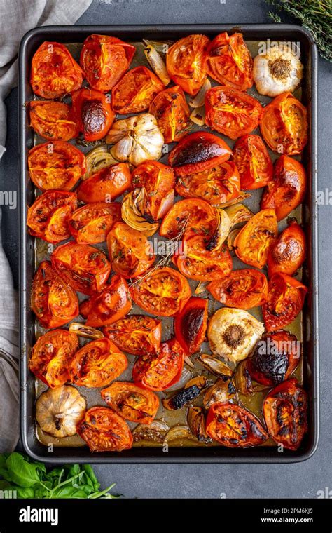 roasted tomatoes, garlic, and onion on a baking sheet