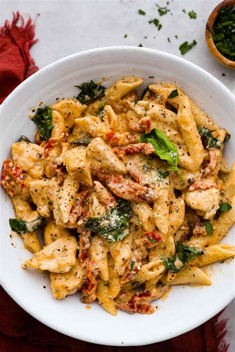 Cajun csirke pasta tálalva, friss fűszernövényekkel megszórva