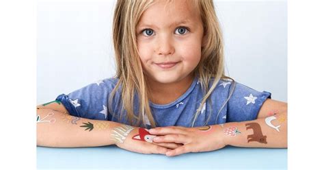 egy személy gondosan felhelyez egy lemosható tetoválást