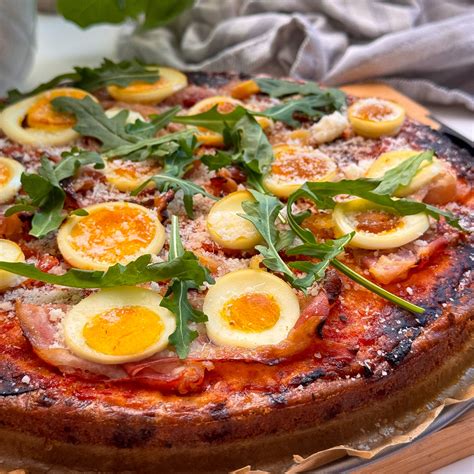 Különböző feltétekkel díszített tojásos pizza alap