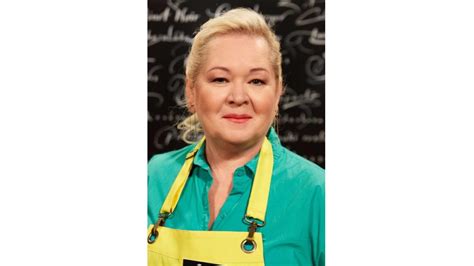 Gizi, aki a konyhában tevékenykedik, mosolyogva