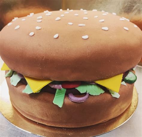 Egy kreatívan elkészített hamburger torta szelete, amely valósághűen imitálja a hamburgert
