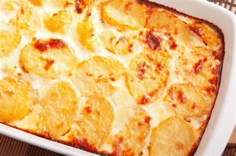 Tálalásra kész, gazdagon megszórt reszelt sajttal rakott burgonya