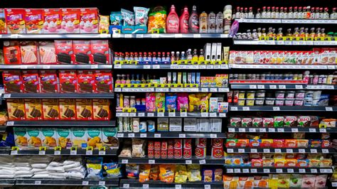 Woman selecting a shower gel from a wide range of options in a beautifully displayed store aisle