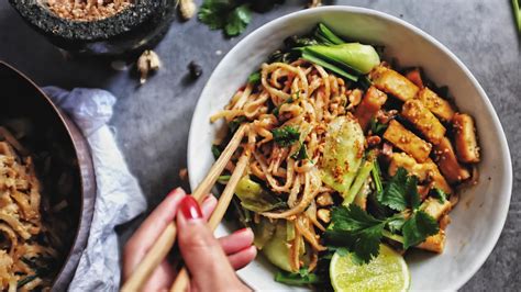 Pad thai tészta tálalva lime gerezdekkel és mogyoróval
