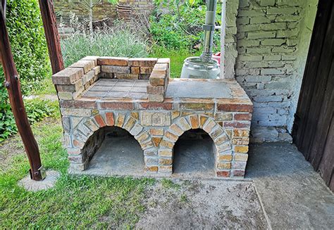 Bontott téglából épített kerti grill tűzterének falazása