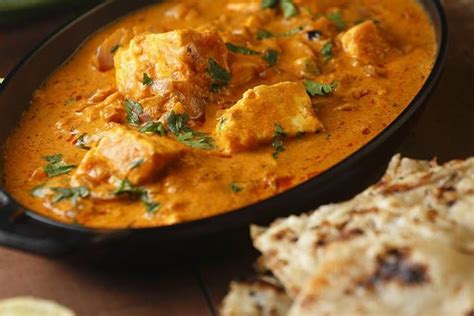 Indiai vajas csirke tálalva, korianderrel megszórva, rizzsel és naan kenyérrel