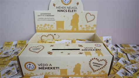 Adománygyűjtő doboz orvosi szimbólumokkal, mögötte mosolygó emberek