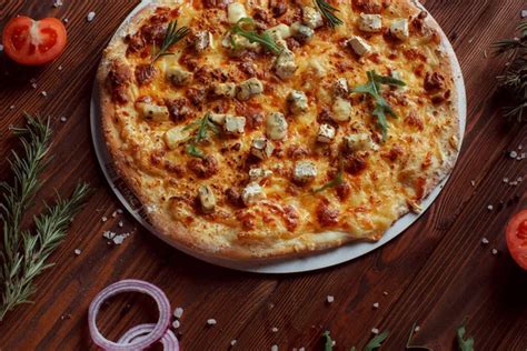 Hangulatos éjszakai környezet, egy forró pizza az asztalon és egy könyv, miközben a háttérben lágy fények világítanak