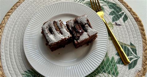 Brownie-kockák egy tányéron, tetejükön porcukorral