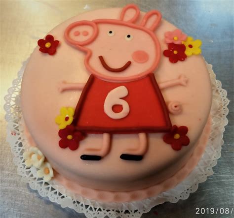 Ünnepi asztalra helyezett, gondosan kidolgozott Peppa malac torta részletei