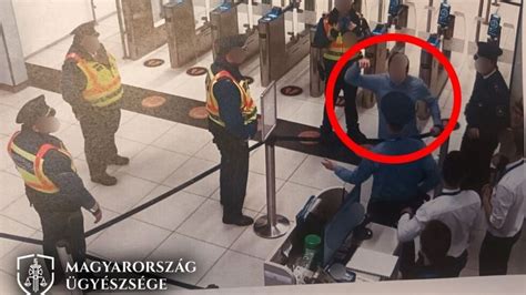 Fotó egy hentesről, amint éppen ellenőrzi a füstölőben lévő sonkák állapotát