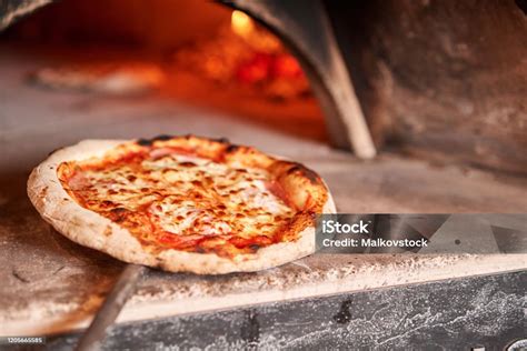 A kemencében készülő friss, forró pizza látványa