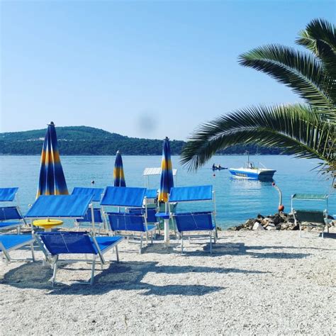 A Medena strand napozóágyakkal és fenyőfákkal