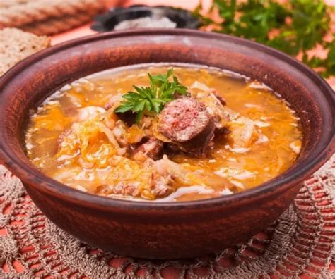 egy gőzölgő tányér gazdag savanyú káposztás leves kolbásszal