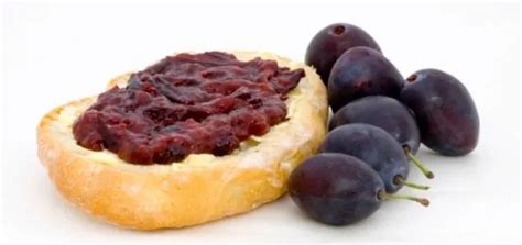 Közelkép a sűrű, sötétlila szilvalekvárról egy friss szelet kenyéren