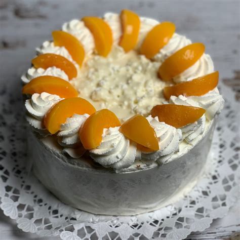 Díszített fehércsokis barackos torta
