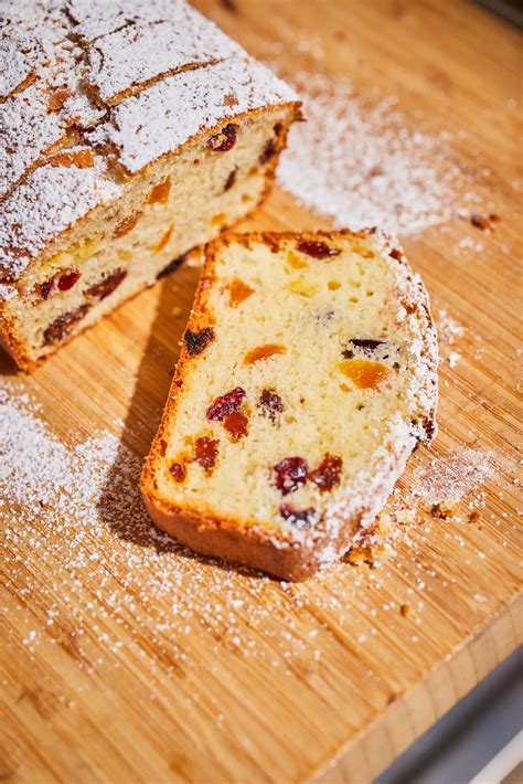egy gőzölgő teásbögre mellett szeletelt, gazdag aszalt gyümölcsös gyümölcskenyér