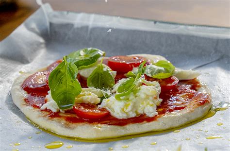 egy gőzölgő pizza képe egy okostelefon mellett, rendelési alkalmazással a képernyőn
