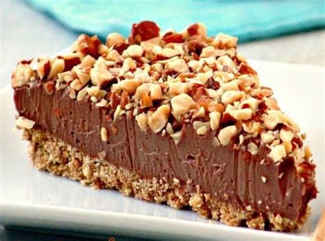 egy szelet krémes Nutellás sajttorta közeli felvétele, tetején pirított mogyoródarabokkal