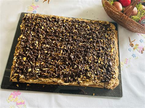 egy rusztikus, diós sütemény szeletelése, háttérben dióval és kávébabbal