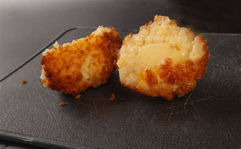 hagyományos szicíliai arancini keresztmetszete sajttal töltve