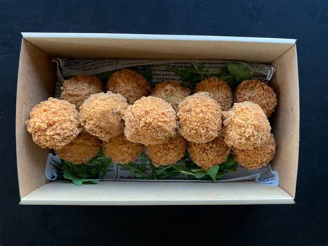 tálalásra kész, forró arancini golyók egy fa deszkán