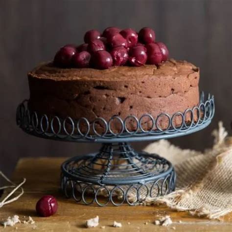 egy elegáns, szeletelt gesztenyetorta, amelyen látszanak a csokoládés és meggyes rétegek