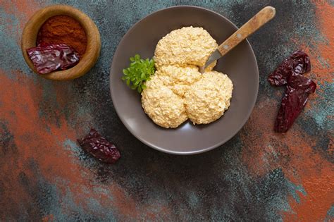 főtt kölesből készített vegán túrópótló, textúrája közelről bemutatva egy fa kanálon