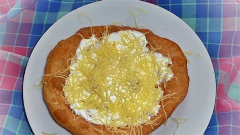 Hagyományos lángos tányéron tejföllel és sajttal