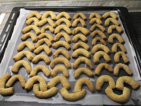 világos, frissen sült diós kiflik egy sütőpapírral bélelt tepsiben