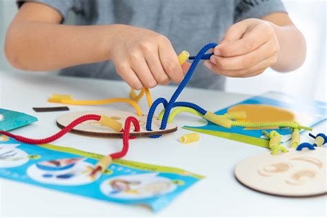 Child developing fine motor skills with tongs