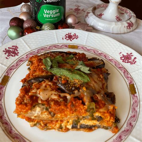 Vegán lasagne tálalása friss zöldségekkel és fűszernövényekkel