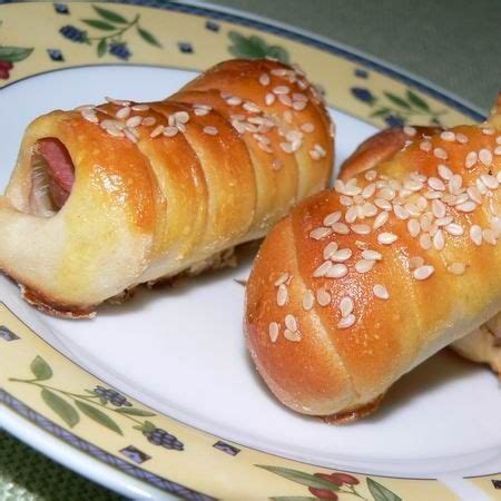 frissen sült, aranybarna virslis tekert kiflik egy tálcán
