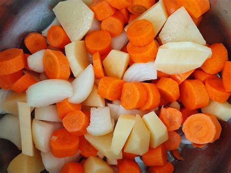 színes zöldségek, sárgarépa, fehérrépa és krumpli szépen felszeletelve egy vágódeszkán